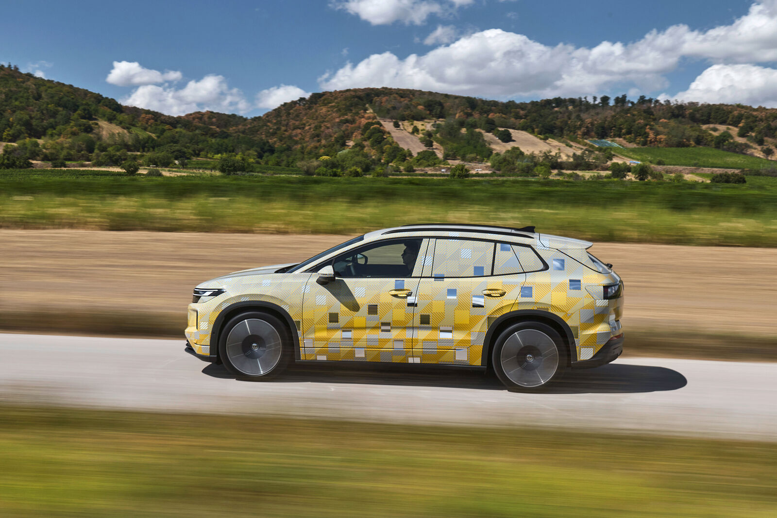 Bočný profil maskovaného prototypu Volkswagenu ID. Tiguan počas jazdy.