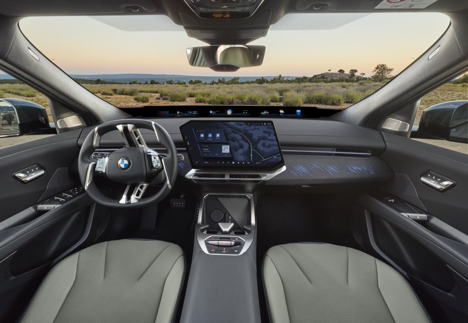 Interiér nového BMW iX4 50 xDrive s širokým digitálnym rozhraním a panoramatickou strechou.